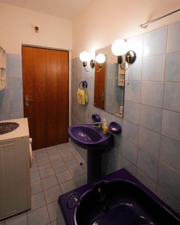 W łazience znajduje się fioletowa umywalka i lustro. w obiekcie Kuća za odmor LEON w mieście Klenovica