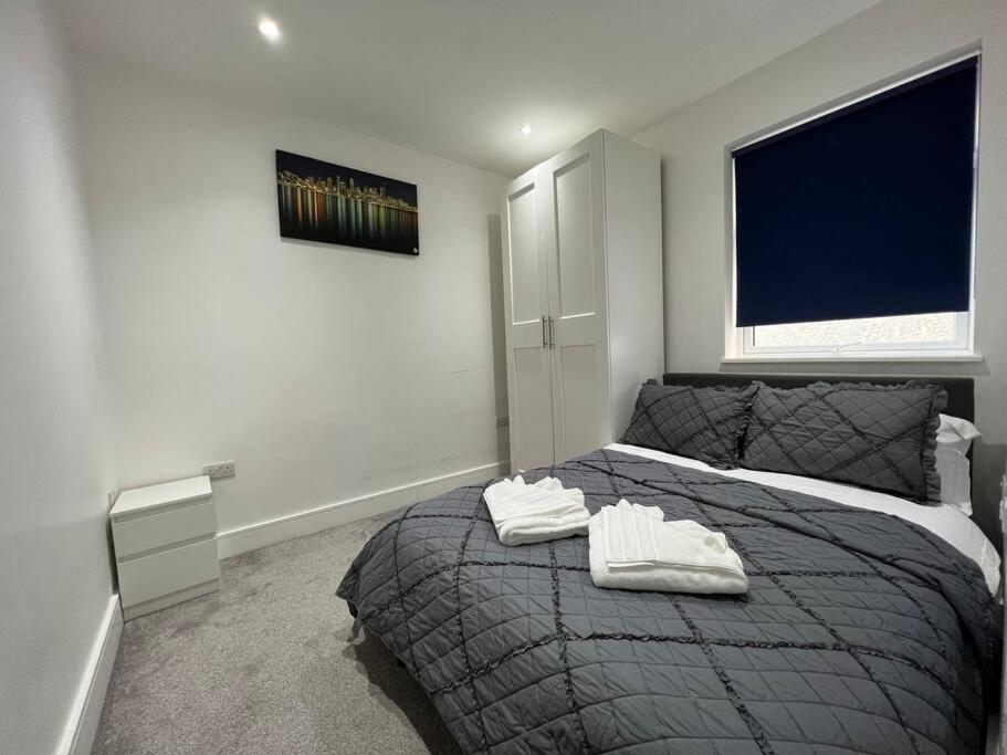 a bedroom with a bed with two towels on it at Star London Bell Lane 3-Bed Oasis with Garden in Hendon