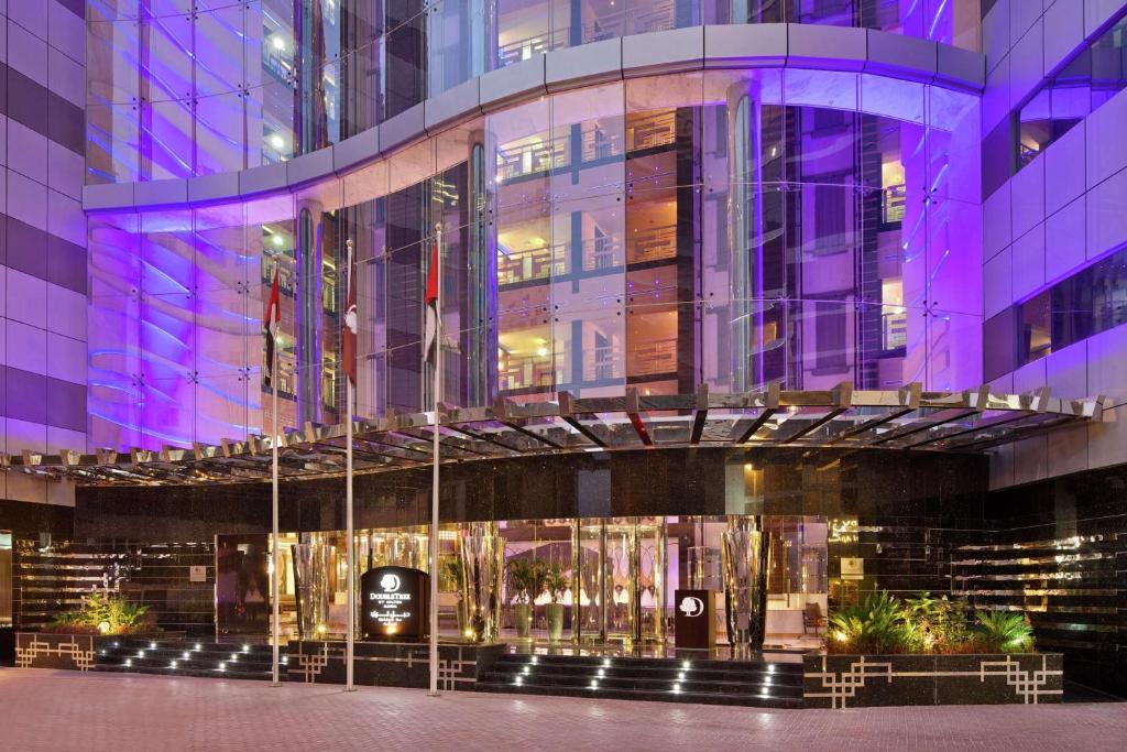 DoubleTree by Hilton Hotel and Residences Dubai – Al Barsha في دبي: تسليم مدخل مبنى في الليل