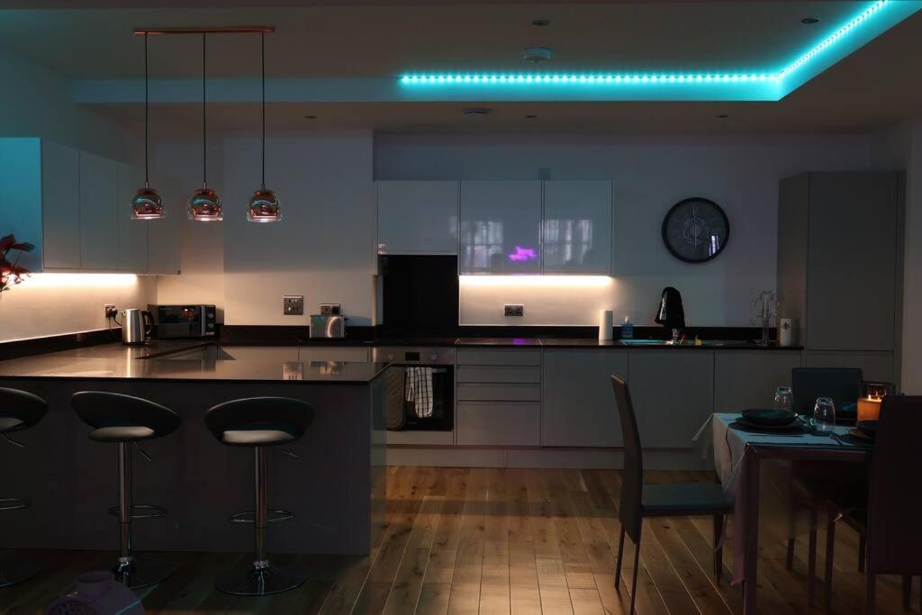 a kitchen with a counter and a table with chairs at Modern house in Birmingham in Birmingham