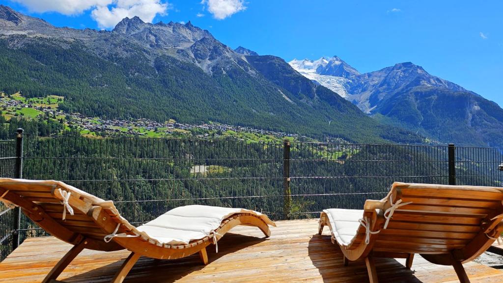 Mattertal Lodge في Embd: سطح مع كرسيين وإطلالة على الجبال