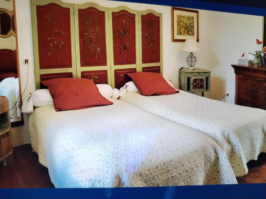 a bedroom with a large white bed with red pillows at Villa Delphina in Vernet-les-Bains