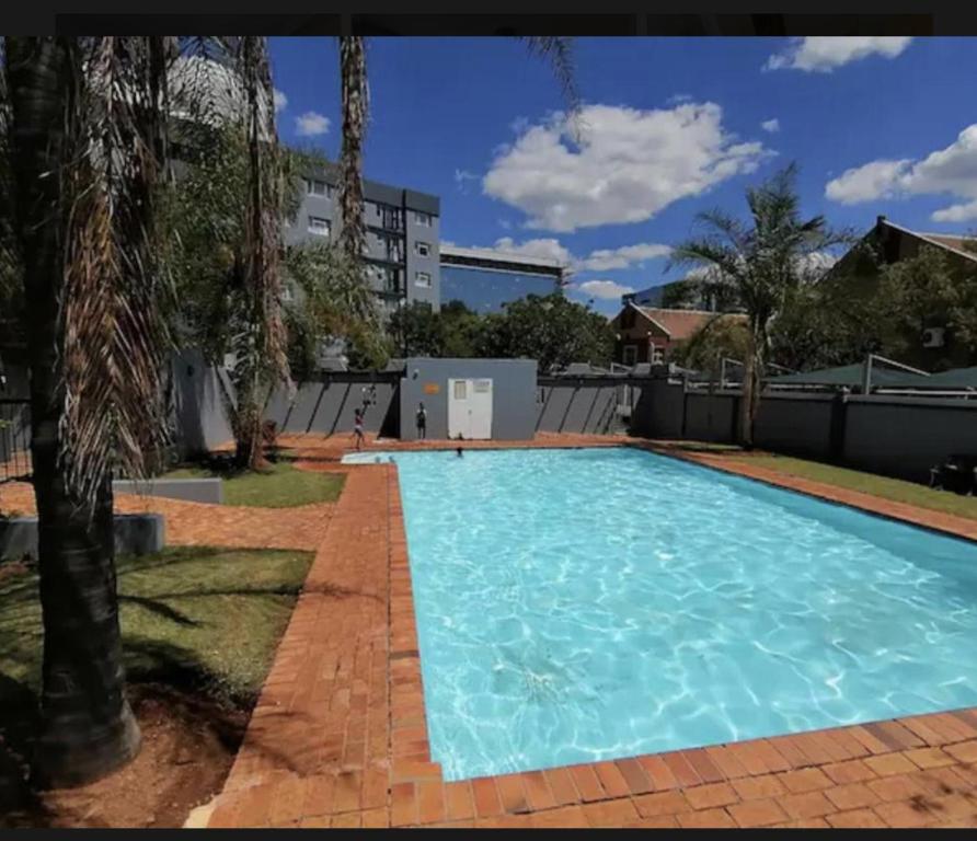 ein großer Pool mit blauem Wasser in der Unterkunft Menlyn Place Staycation in Pretoria