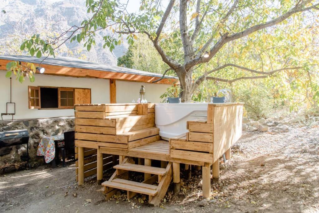 サン・アルフォンソにあるCabaña de montaña (jacuzzi exterior)の木造家屋の上にバスタブが備わります。