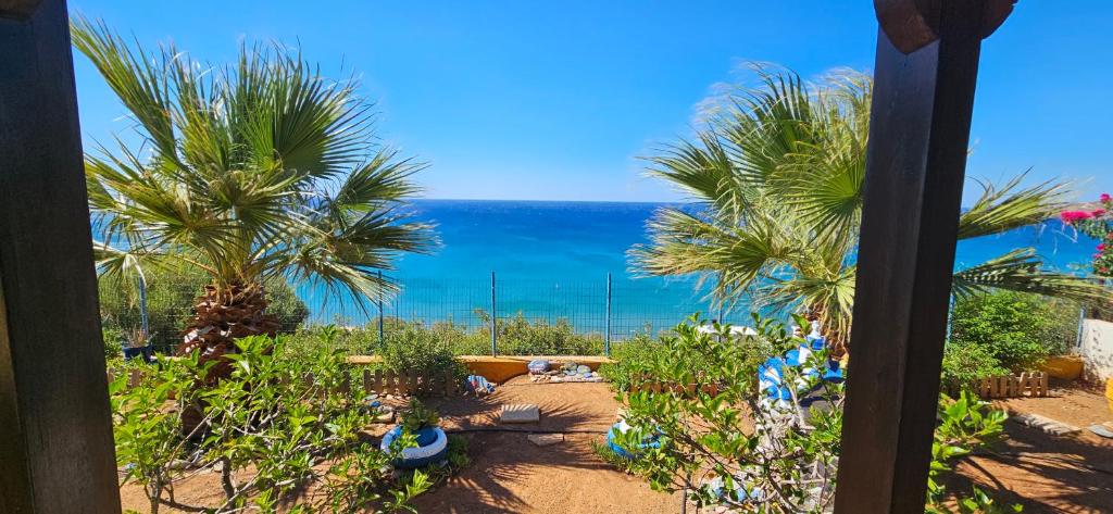 vistas a una playa con palmeras y al océano en Ra's Seacastle, en Tsoutsouros