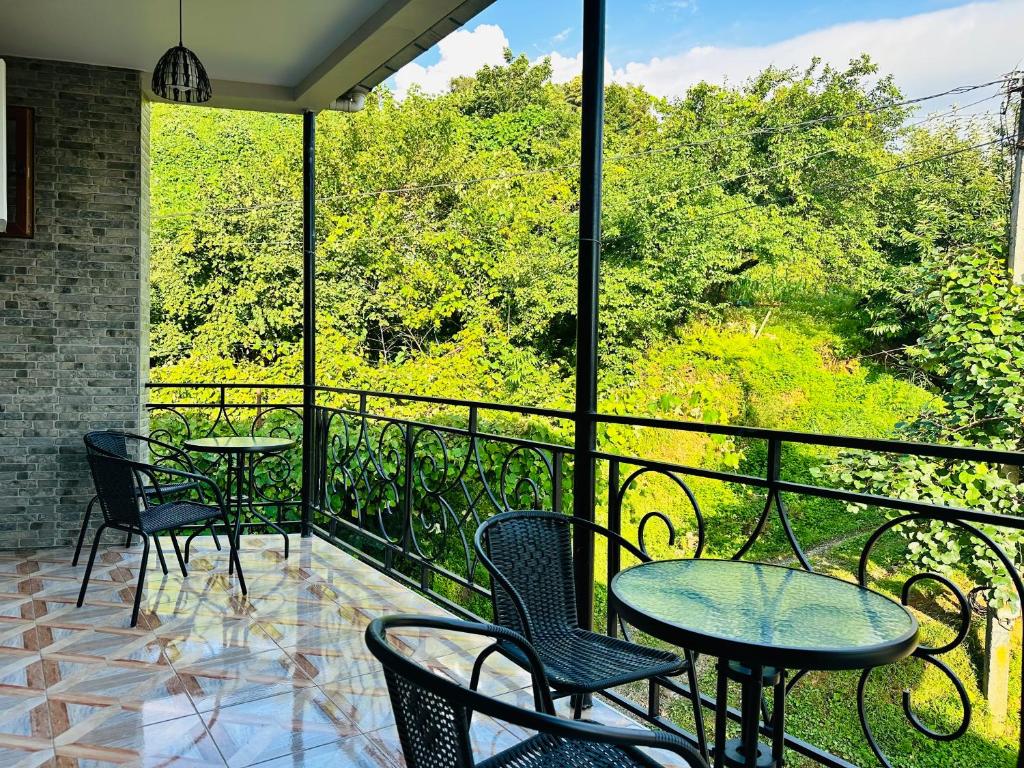 a patio with tables and chairs on a balcony at House in Tsikhisdziri in K'obulet'i