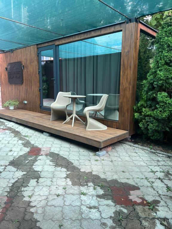 ein Haus mit einem Tisch und Stühlen auf einer Veranda in der Unterkunft Monaco in Chişinău