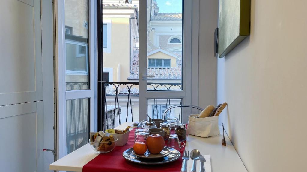 einen Tisch mit einem Teller Essen und Blick auf einen Balkon in der Unterkunft NTB Roma in Rom
