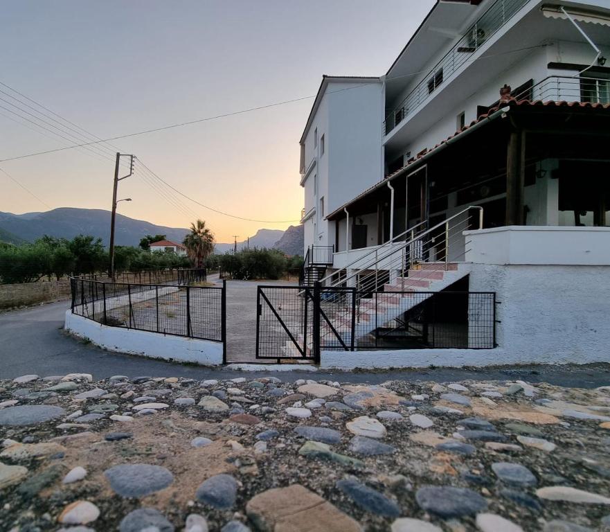 a building with a gate and rocks in front of it at Thassa Beach Apartment No1 (with mountain view) in Leonidion