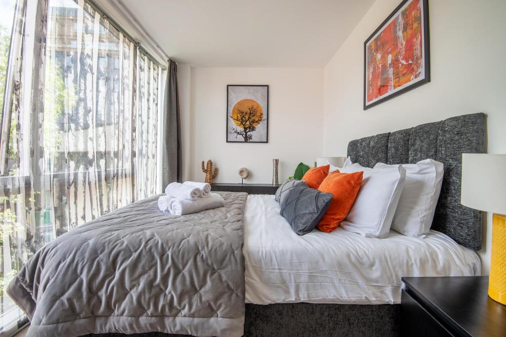 a bedroom with a bed and a large window at Stunning 2Bed BRICK LANE Apartment in London