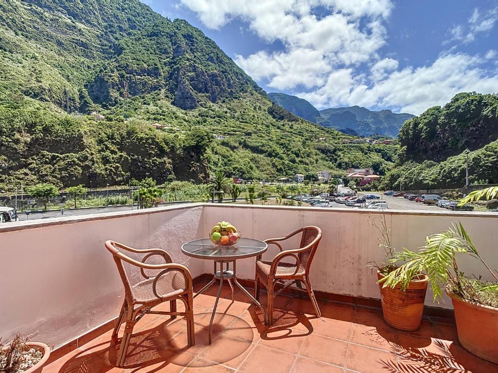 d'une table et de chaises sur un balcon avec vue sur la montagne. dans l'établissement Amarelo Apartment by Atlantic Holiday, à São Vicente