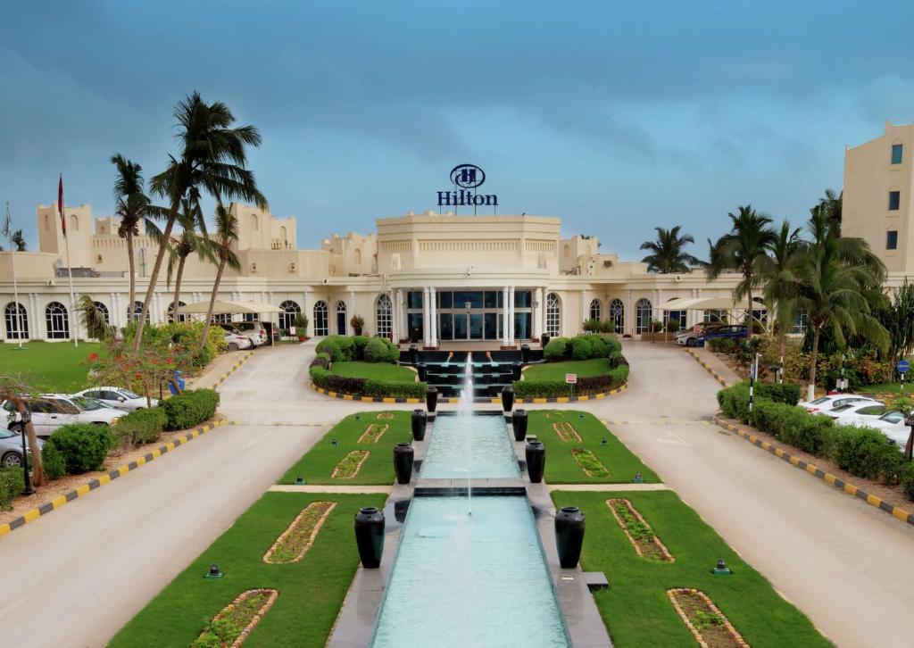 a building with a fountain in front of it at Hilton Salalah Resort in Salalah