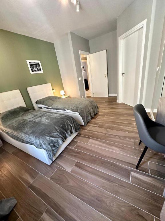 sypialnia z 2 łóżkami, biurkiem i krzesłem w obiekcie HH Hermoso Housing ALESSANDRIA w mieście Alessandria