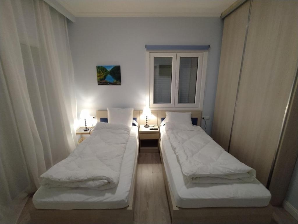twee bedden in een kamer met een raam bij Marena B&B in Pogradec