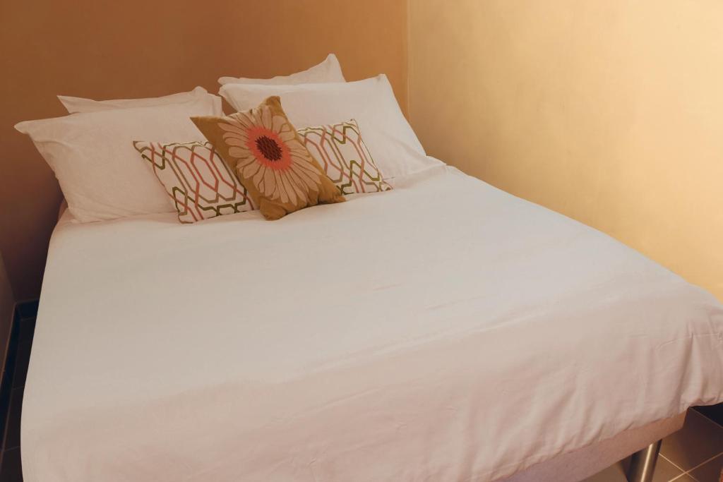 a white bed with white sheets and pillows at Appartement Le Saint-Etienne avec Terrasse in Beaune