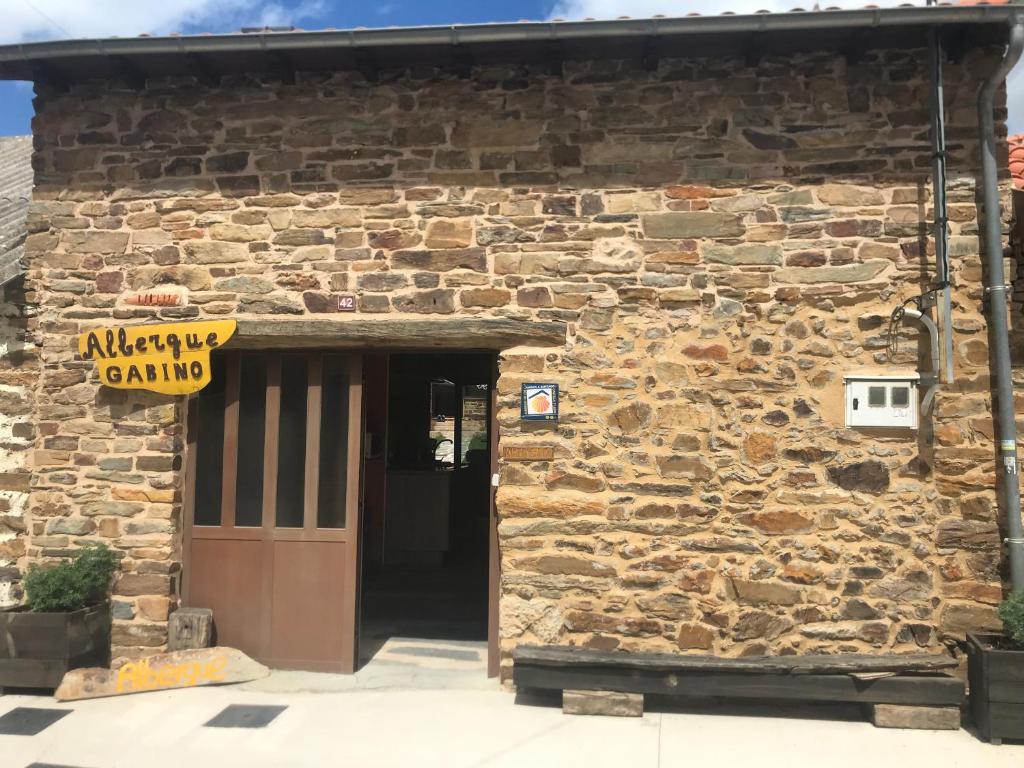 einen Eingang zu einem Steingebäude mit einer Tür in der Unterkunft Albergue Gabino in El Ganso