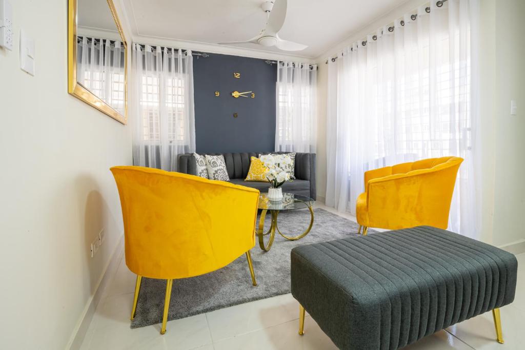 a living room with yellow chairs and a couch at Luxury, cozy apartment Malecon / 3 min Downtown in Santo Domingo
