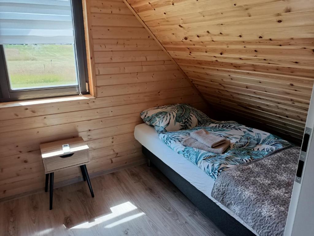 a room with a bed and a table in a cabin at Karla in Pleśna