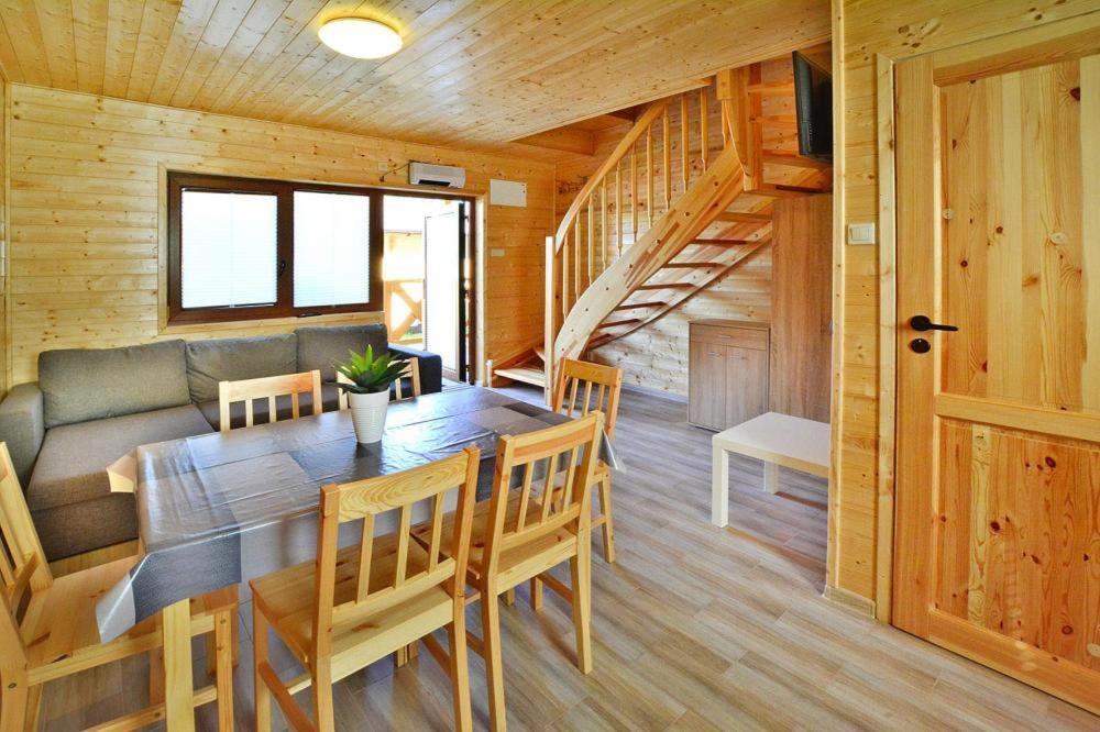 a dining room with a table and chairs and a staircase at Comfortable holiday homes Mielno in Mielno