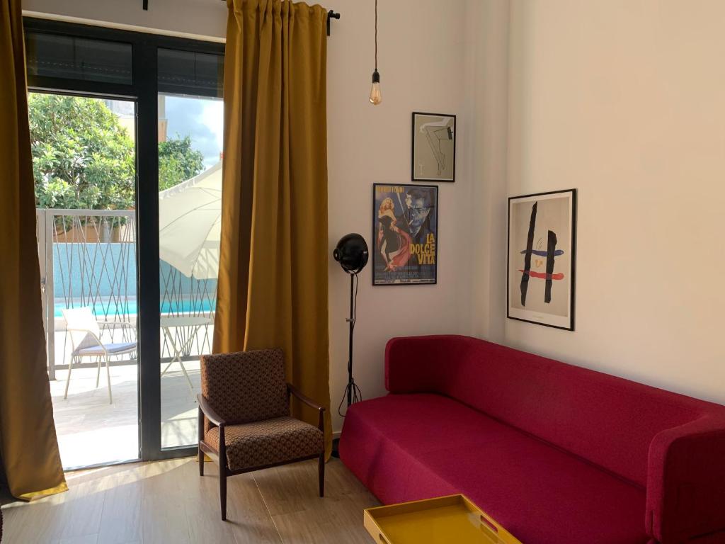 a living room with a red couch and a window at Sunny studio apartment Chiara in Tivat
