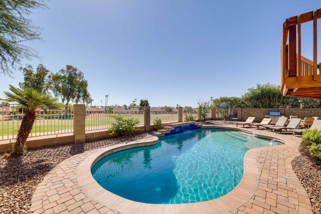 a swimming pool in a yard with chairs and a fence at Stunning Phoenix Oasis with Golf Course Views! in Phoenix