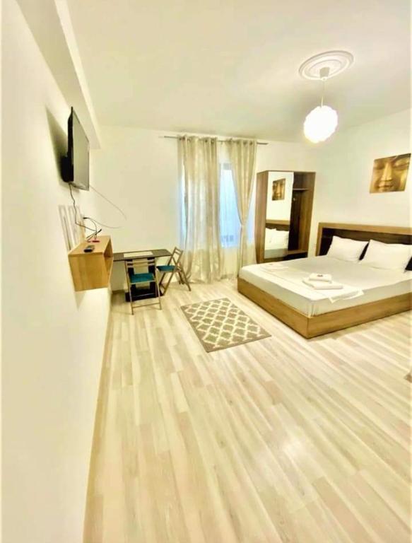 a bedroom with a bed and a desk in it at Hotel Ipsilanti in Iaşi