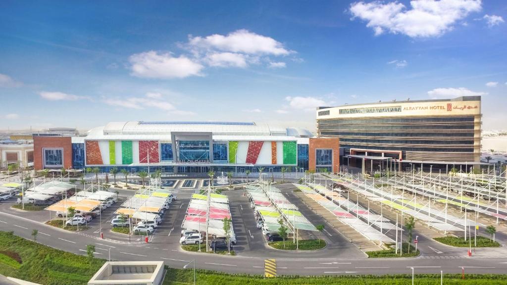 a parking lot in front of a large building at AlRayyan Hotel Doha, Curio Collection by Hilton in Doha