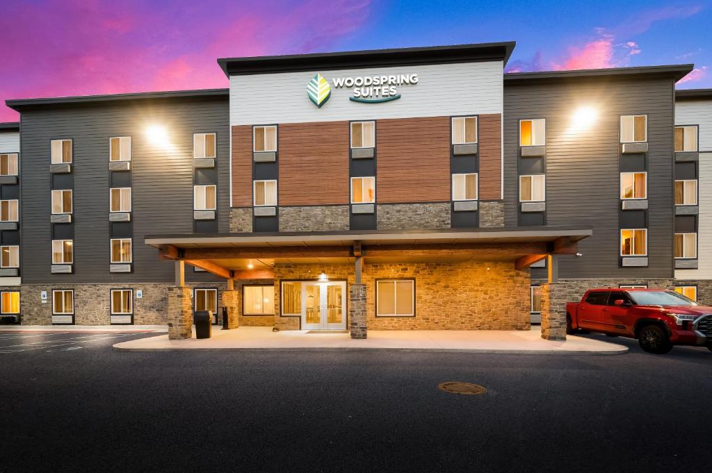a hotel with a car parked in front of it at WoodSpring Suites East Lansing - University Area in East Lansing