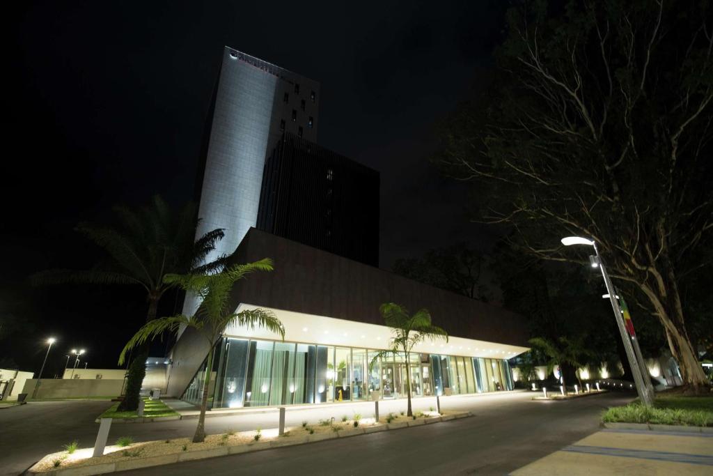 a building with a tall tower at night at Doubletree By Hilton Pointe-Noire City Centre in Pointe-Noire