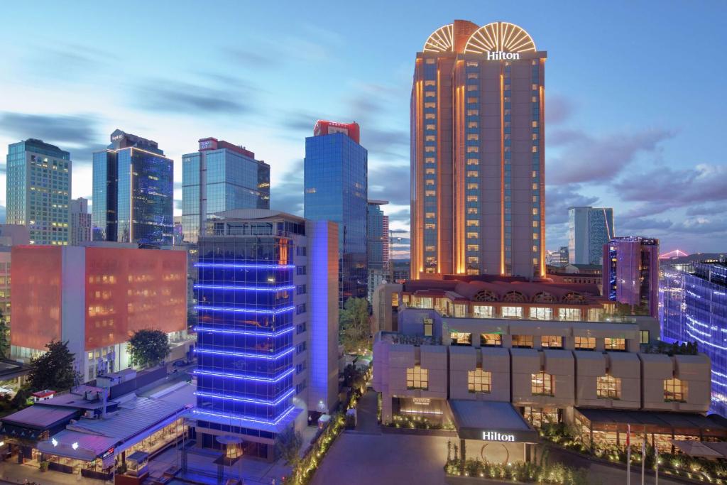 a city skyline with tall buildings at night at Hilton Istanbul Maslak in Istanbul