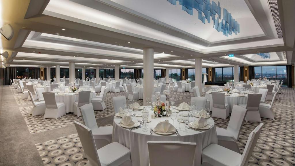 a banquet hall with white tables and white chairs at Hilton Istanbul Maslak in Istanbul