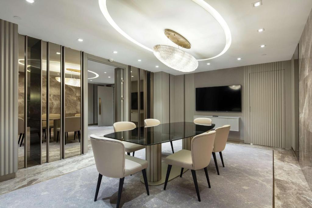 a dining room with a black table and white chairs at Hilton Istanbul Maslak in Istanbul