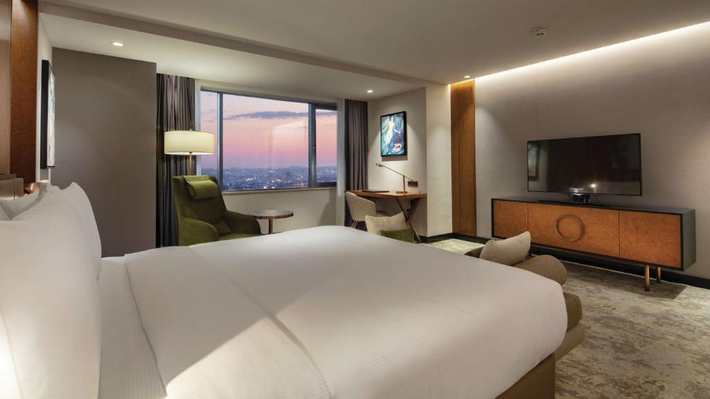 a hotel room with a large bed and a television at Hilton Istanbul Maslak in Istanbul