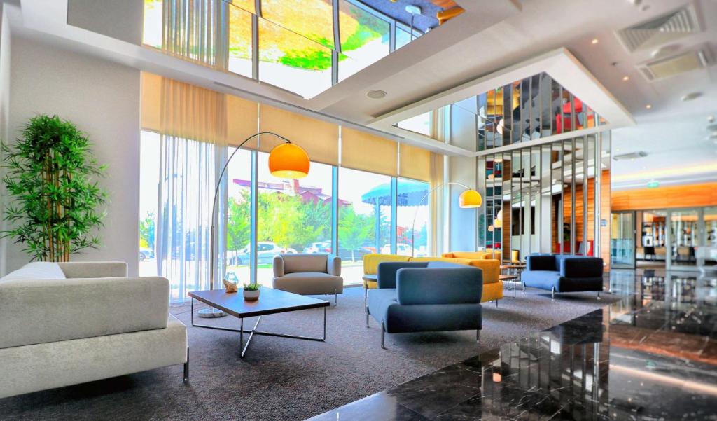 un vestíbulo con sofás, sillas y ventanas en DoubleTree by Hilton Ankara Incek, en Ankara