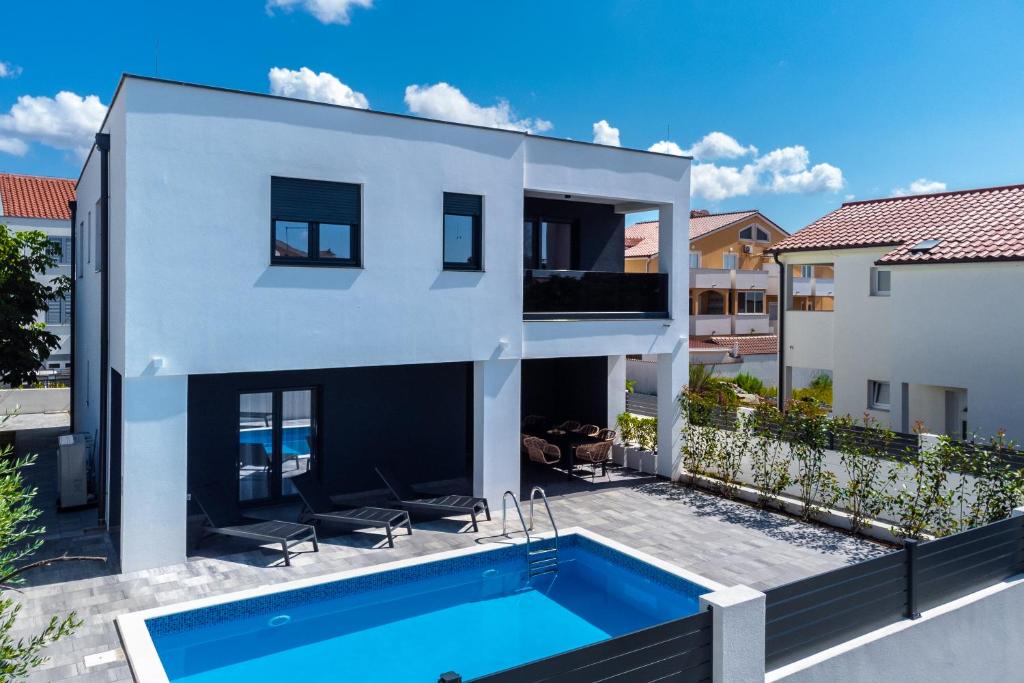 uma casa branca com uma piscina em frente em House with pool Villa Angelo Vrsi em Vrsi