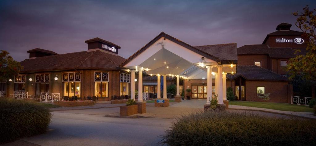 a large building with lights in front of it at Hilton East Midlands Airport in Castle Donington