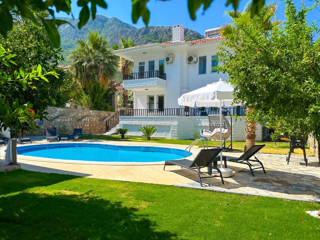 a villa with a swimming pool and a house at Villa Aivin in Fethiye