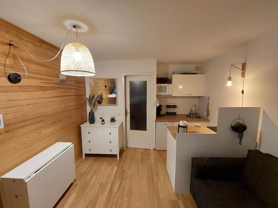 um quarto com uma cozinha e uma sala de estar com em Joli studio 4 couchages aux pieds des pistes em Puy-Saint-Vincent