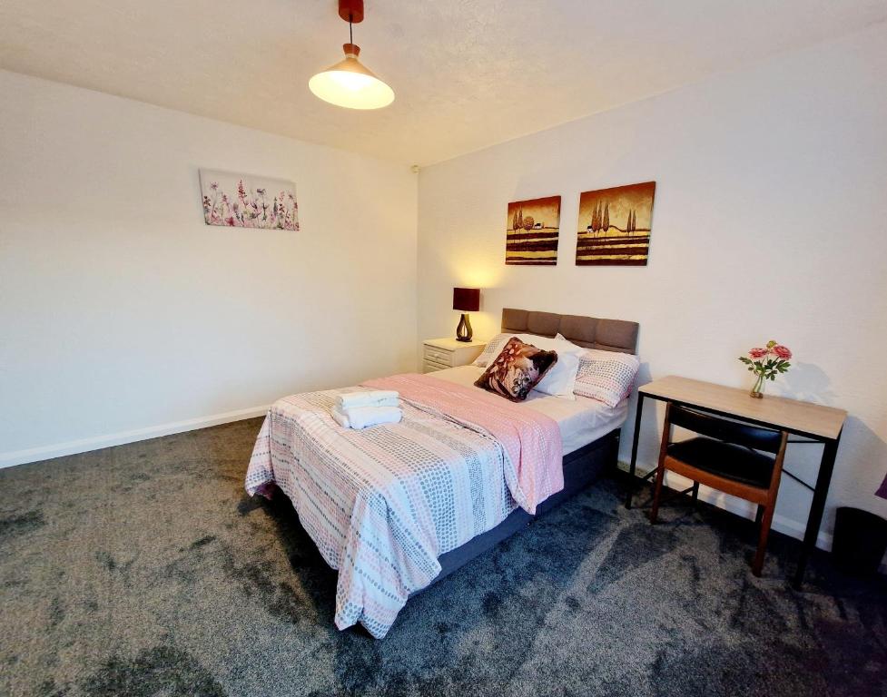 niewielka sypialnia z łóżkiem i biurkiem w obiekcie Chimes-Company & Family Stay, 2 Bedroom House + Free parking w mieście Tamworth
