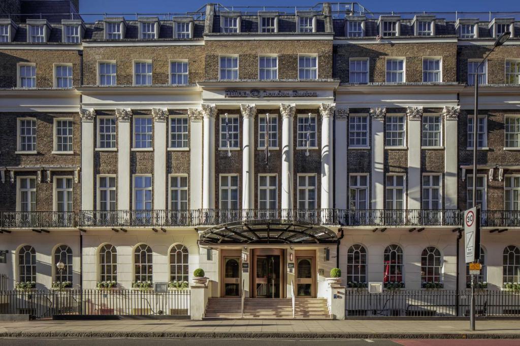 Un grand bâtiment avec balcon se trouve dans une rue. dans l'établissement Hilton London Euston, à Londres