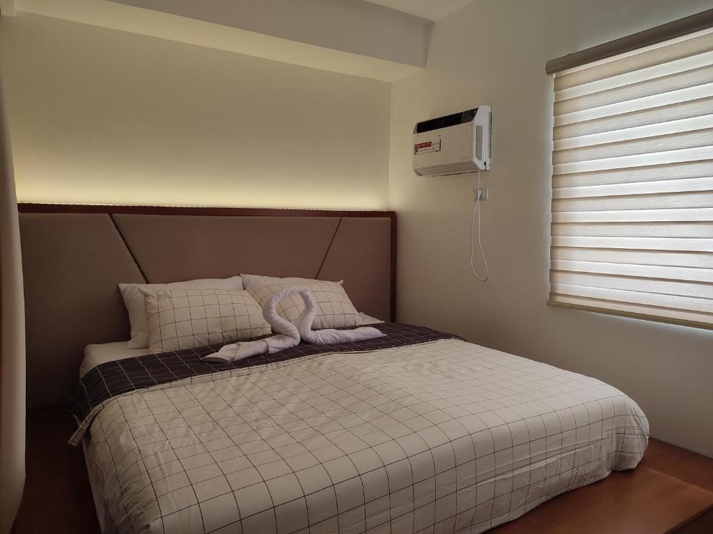 een slaapkamer met een bed met een wit dekbed bij The Zen Suites at Matina Enclaves in Davao City