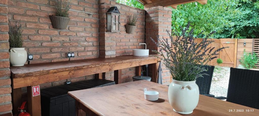 a patio with a wooden table and a brick wall at Apartmány Ve starém pivovaru in Malešov