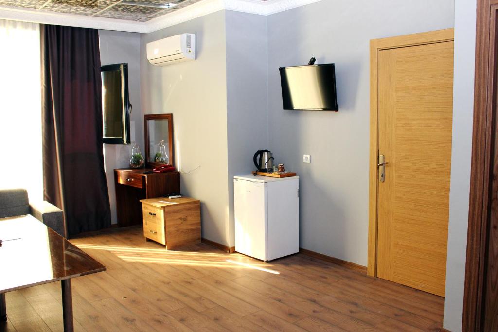 a room with a refrigerator and a wooden floor at biglife hotel in Istanbul