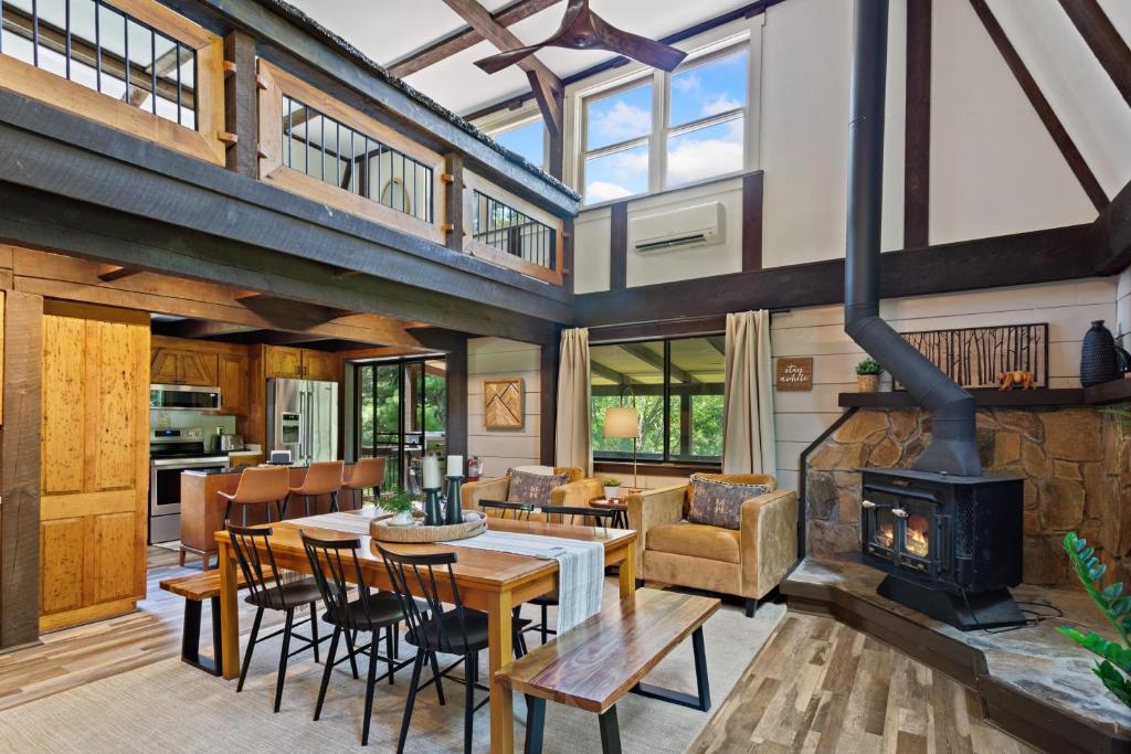 an open living room with a fireplace and a table and chairs at Banner Barn in Banner Elk