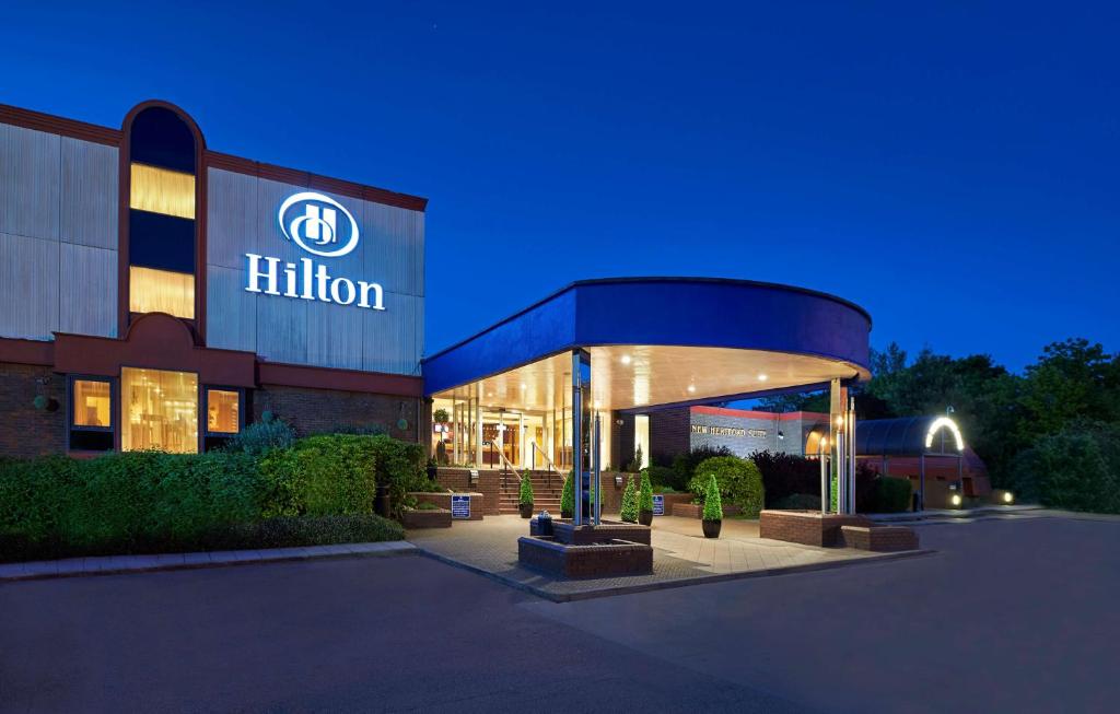 un bâtiment avec un panneau hilton la nuit dans l'établissement Hilton London Watford, à Watford