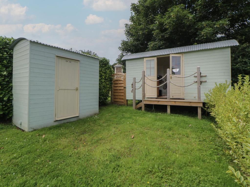 a small shed with a porch and a deck at Flora's Hut in Liskeard