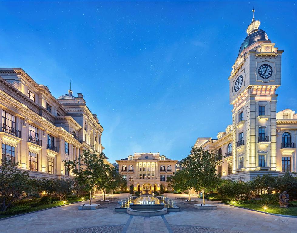 um grande edifício com uma torre de relógio em frente em Hilton Beijing Daxing em Pequim