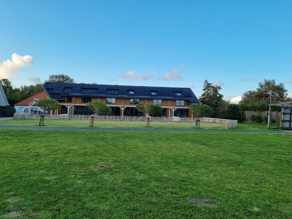 een groot huis met een groen veld ervoor bij DW Castricum in Castricum