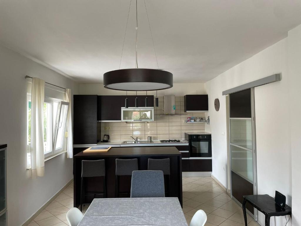 a kitchen with a table and a black counter top at Apartman Maja in Vodice