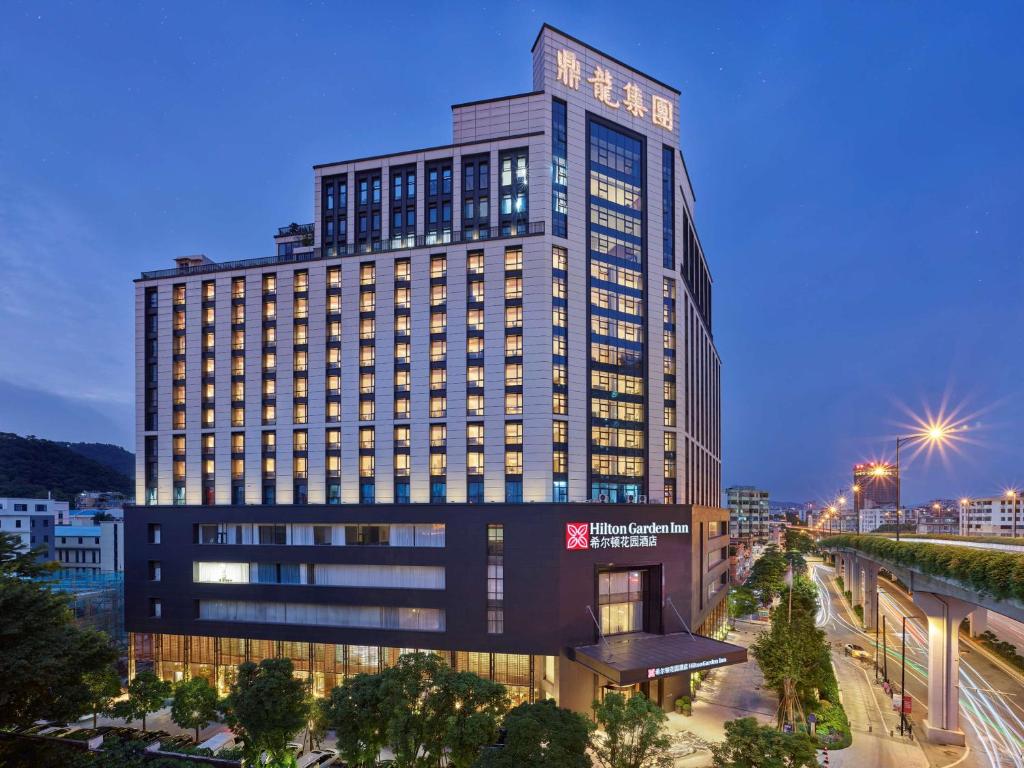 ein Bild eines hohen Gebäudes in der Nacht in der Unterkunft Hilton Garden Inn Guangzhou Tianhe- Free Canton Fair Shuttle Bus in Guangzhou